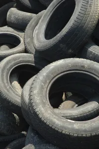 A large pile of old, worn tires stacked haphazardly