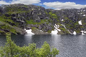 Large snowfields is reflected in the water of the lake