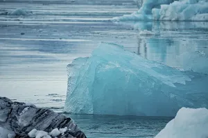 Large textured iceberg floating in a serene body of water