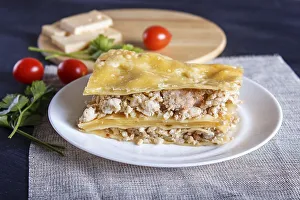 Lasagna with minced meat and cheese on black wooden background