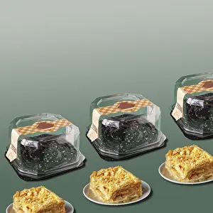 Layered cake with cream and an empty box on a green background