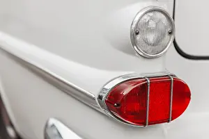 Left tail light with reversing light on a white vintage car with chrome trim