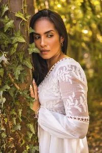 Lifestyle, brunette girl with straight hair in a beautiful white dress in a park resting in summer