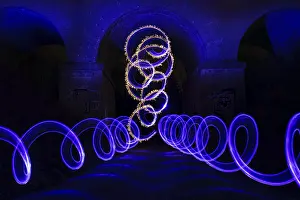 Light painting with blue and yellow spirals forming glowing patterns in the dark