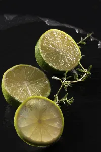 Three lime slices on a black stone plate