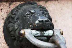 Lion head made of bronze, holding the end of a chain
