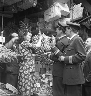 Lisbon, Portugal, 1949. Two swedish airline captains in their uniforms is buying bananas from a store assisted by a girl of the shop staff. Kristoffersson ref AR87-5, Europe