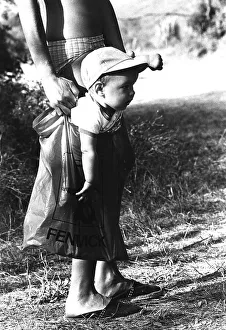 A little boy is carried in a plastic bag