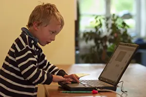 Little boy typing concentrated on laptop, Germany