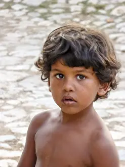 Little Cuban boy on the street in front of an old wall