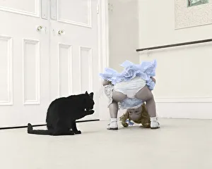 Little girl playing with black cat