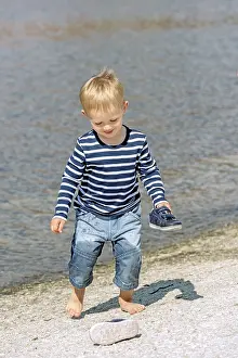 Little preschool boy playing on shore outdoors