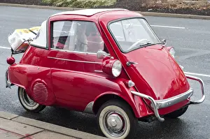 Little red old vintage car on street background