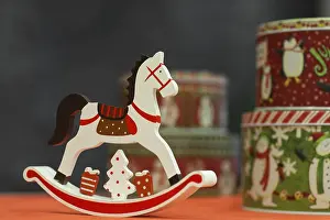 Little toy rocking horse with a gift box on a blurred background