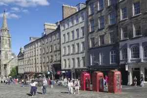 Lively street view with historic buildings and striking red telephone boxes in daylight