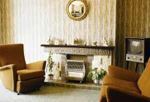 Living room with television, electric fireplace and armchairs, England, photographed in 1962