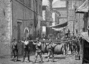 Load carriers in Armenia carrying a large pulley with wire rope