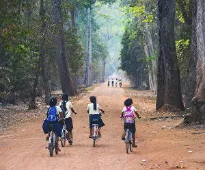Local children ride bicycles, way to school