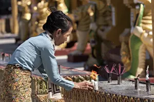 Local woman lighting candles, sacrificial offerings