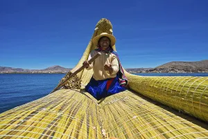 A local woman rowing a traditional boat made of totora reeds on Lake Titicaca