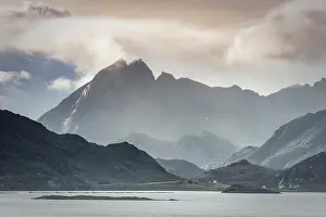Lofoten mountains in haze and clouds by the fjord