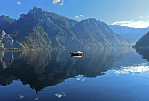 Lonely boat anchored on the mirror-smooth water of Lake Lake Traun