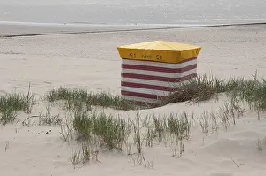 Lonely striped beach chair on the sandy shore with sea view