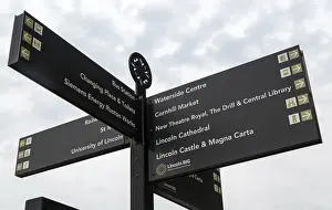 Looking up at signpost pointing to places of interest