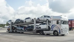 A lorry transports several new cars
