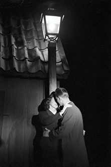 Love in the 1950s. A young couple in the evening are standing under a street lamp kissing. Sweden 1953 ref binder 1
