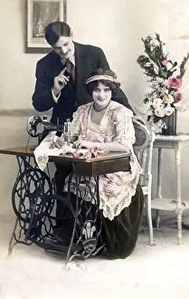 Lovers flirting, woman sitting at the sewing machine