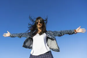 Low angle view of a similing woman with her arms opened outdoors