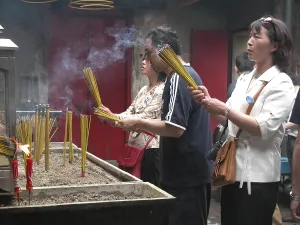 MAC, Macau: People praying in a buddhist temple in Macau's old town