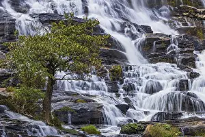 Mae Ya waterfall with cascading flowing water surrounded by lush tropical vegetation