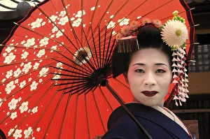 Faces Of The World Prints: A Maiko, a trainee Geisha, carrying a red sun parasol or umbrella