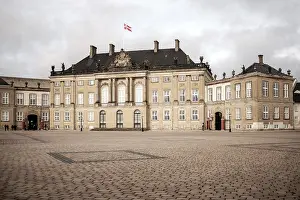 A majestic historic building with a Danish flag