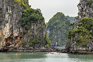 Majestic limestone cliffs surround calm waters as kayaks glide serenely through the scenery