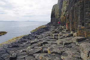Majestic rock formation with basalt columns on a rugged coastline by the sea