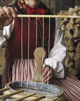 Making candles. A woman dressed in traditional Swedish folk costume are making candles