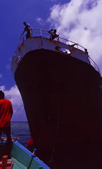 Maldives: Dhoni on the bow of a cargo ship