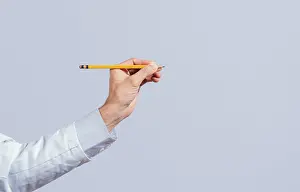 Male hand holding a pencil on a blank