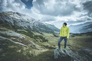 Male mountain climber with backpack is enjoying the view