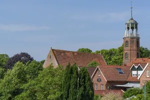 Maltese church tower surrounded by brick buildings and red roofs