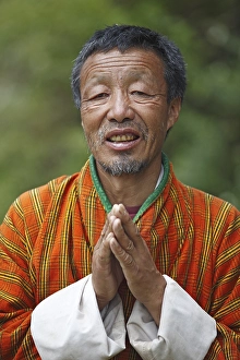 Man, 58 years, in Gho-dress with hands clasped