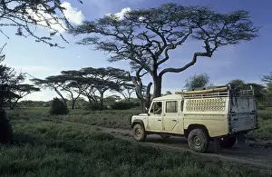Man with binoculars sitting in a landrover