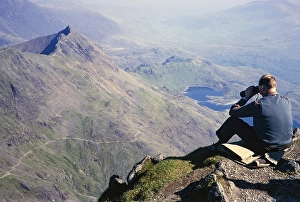 Man with binoculars on the summit of Mount Snowdon, Snowdonia, North Wales, Uk 1966 to the lake Llyn Llydaw