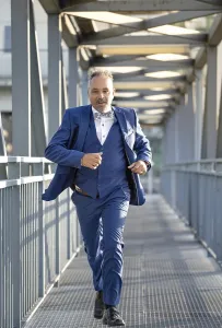 Man in blue suit fleeing over bridge