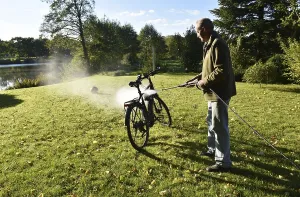 Man cleans bicycle with high-pressure cleaner