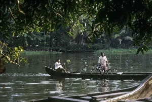 A man crossing the backwater with bicycle