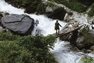 Man crossing wooden pool over river